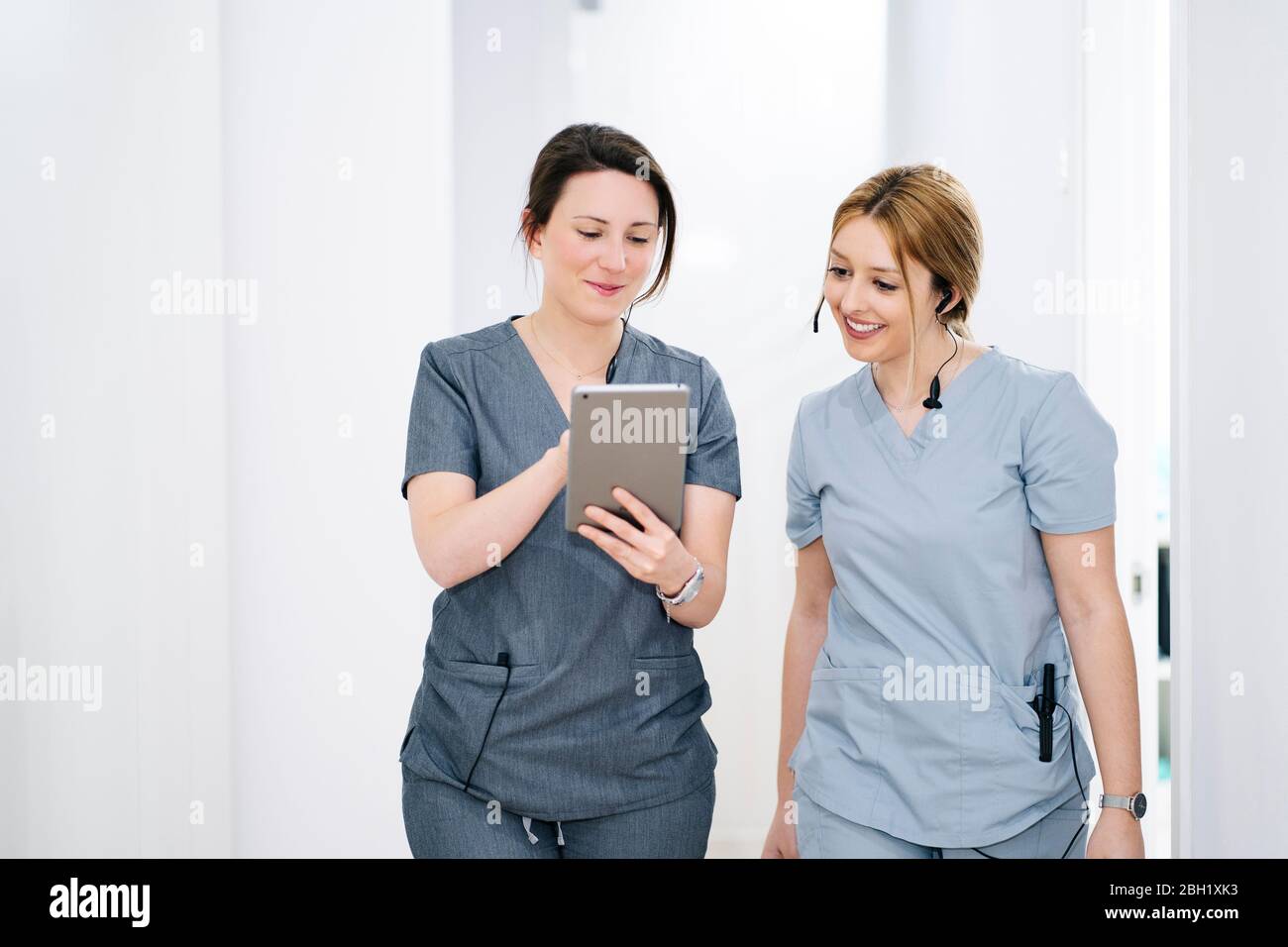 Due segretari medici con cuffia e tablet in pratica medica Foto Stock