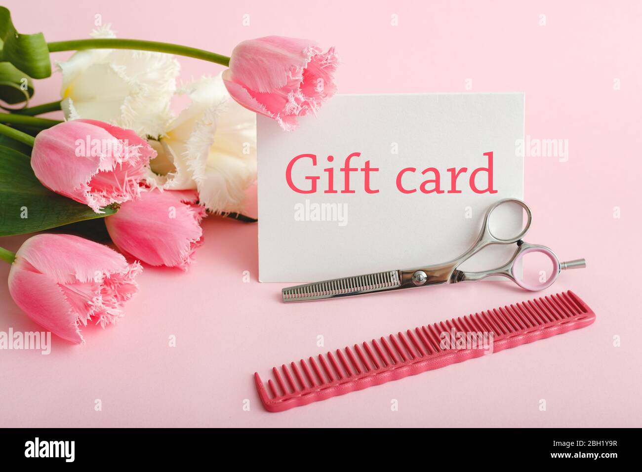 Buono regalo in mazzo di fiori su sfondo rosa da salone di bellezza a moglie, madre, figlia, nonna. Buono regalo per donna. Sorpresa Foto Stock