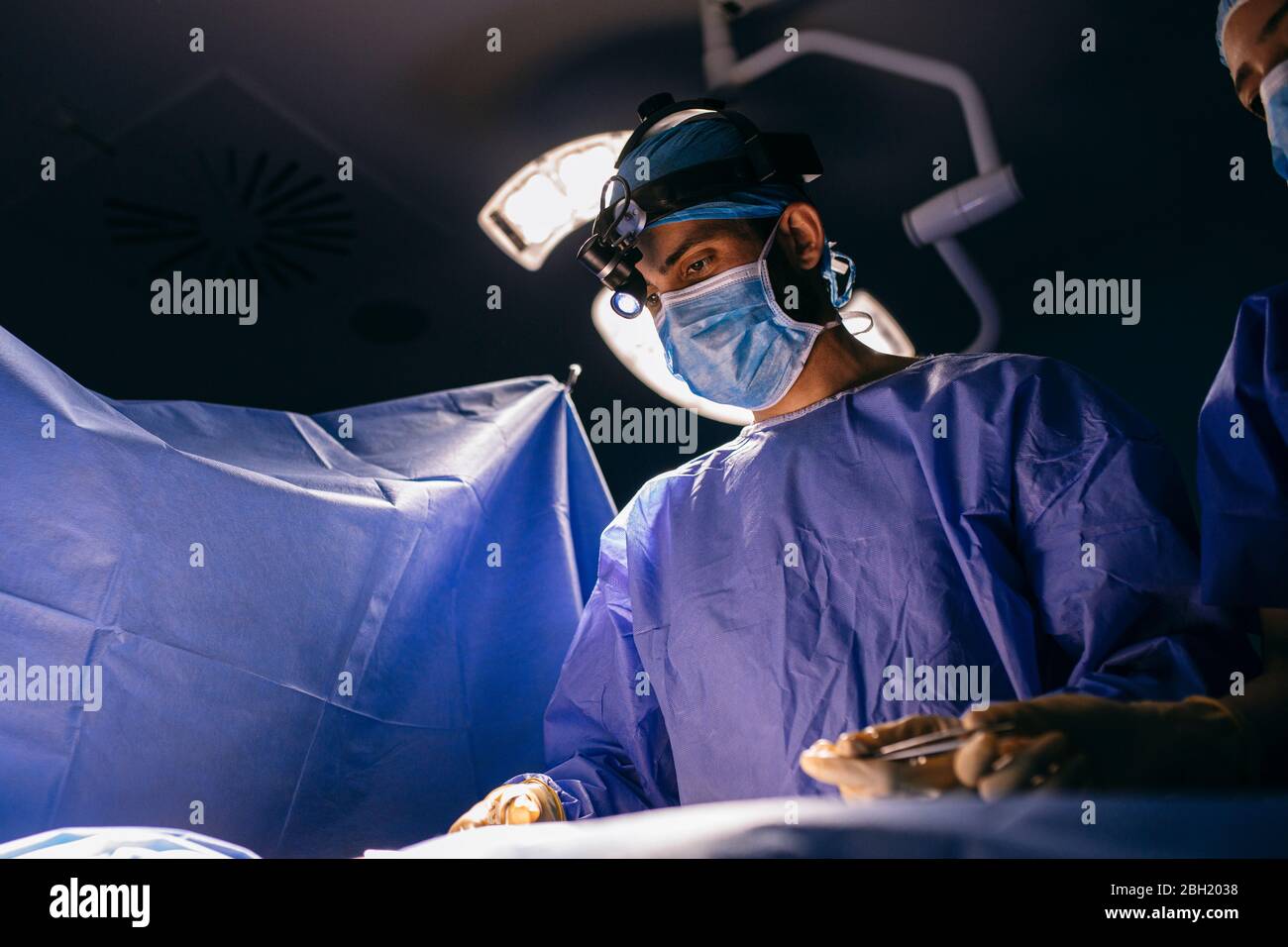 Infermiere e chirurgo in sala operatoria durante un intervento Foto Stock