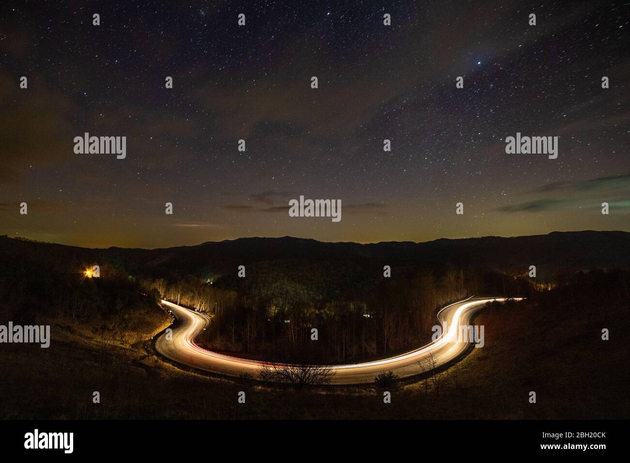 Il sentiero leggero di un'auto delinea una strada di notte su Pine Mountain, Ky. Foto Stock