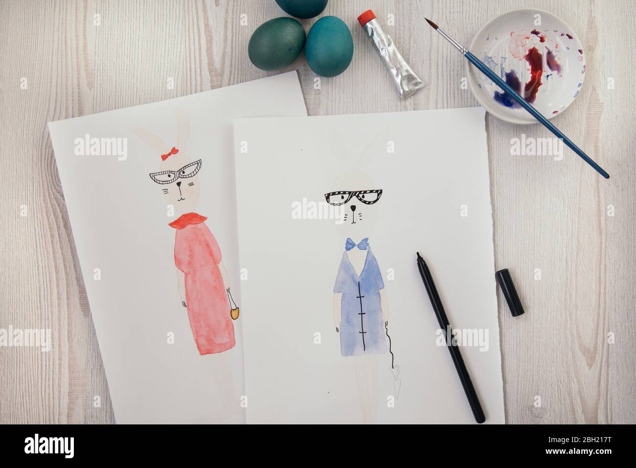 Uova di Pasqua e due dipinti acquerelli di coniglietti antropomorfi di Pasqua Foto Stock