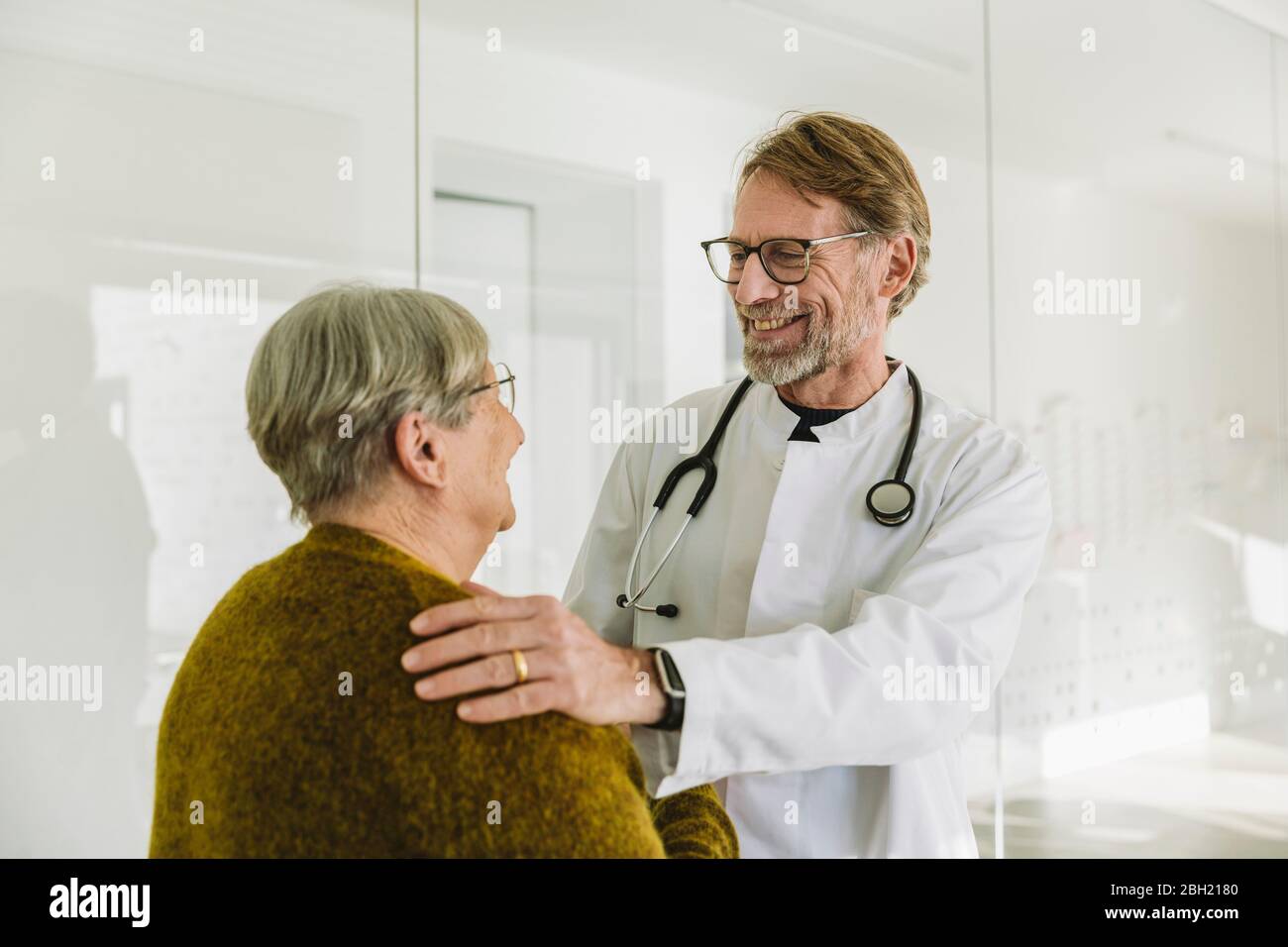 Sorridente medico e paziente anziano nella pratica medica Foto Stock