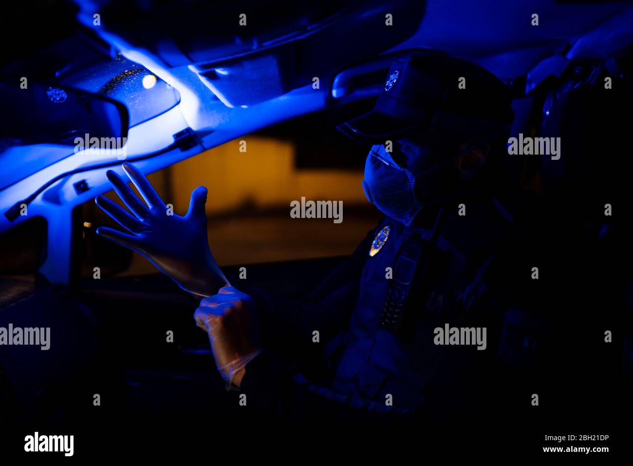 Poliziotto in missione di emergenza, indossando guanti protettivi Foto Stock