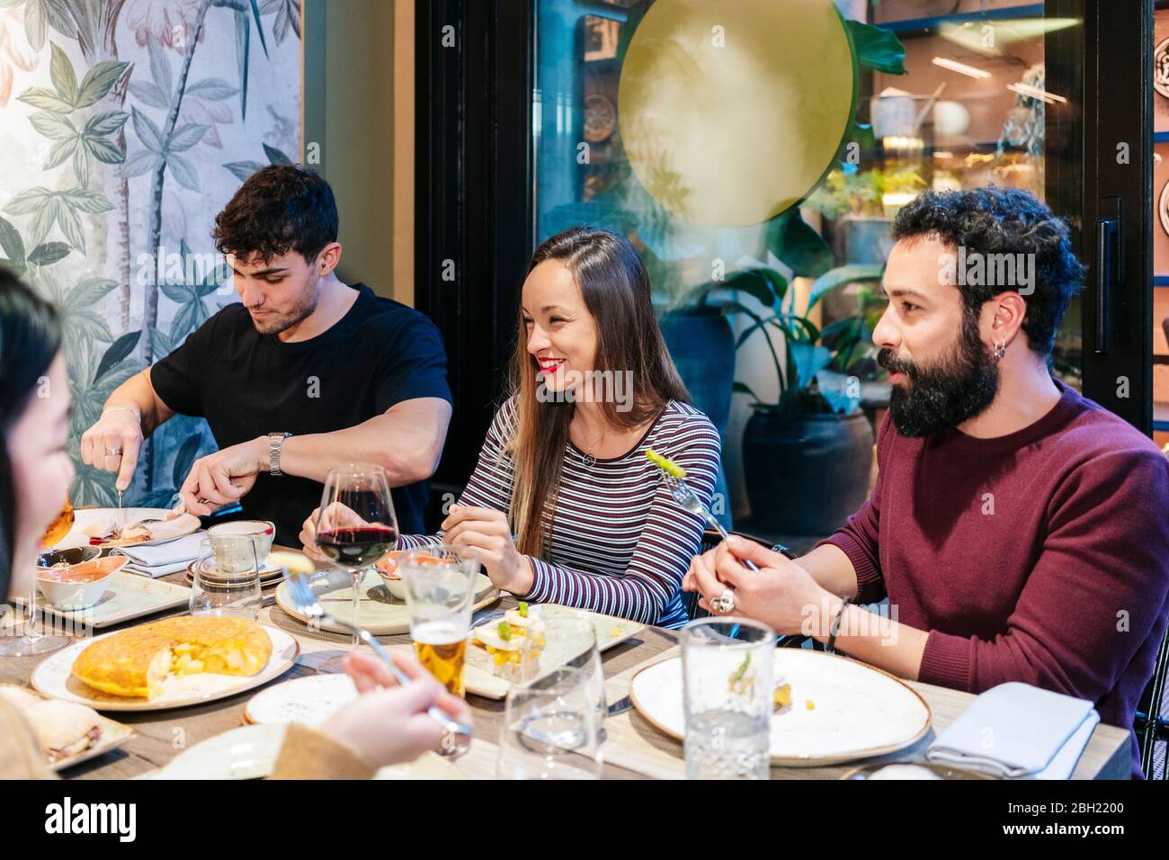 Amici che cenano in un ristorante elegante Foto Stock