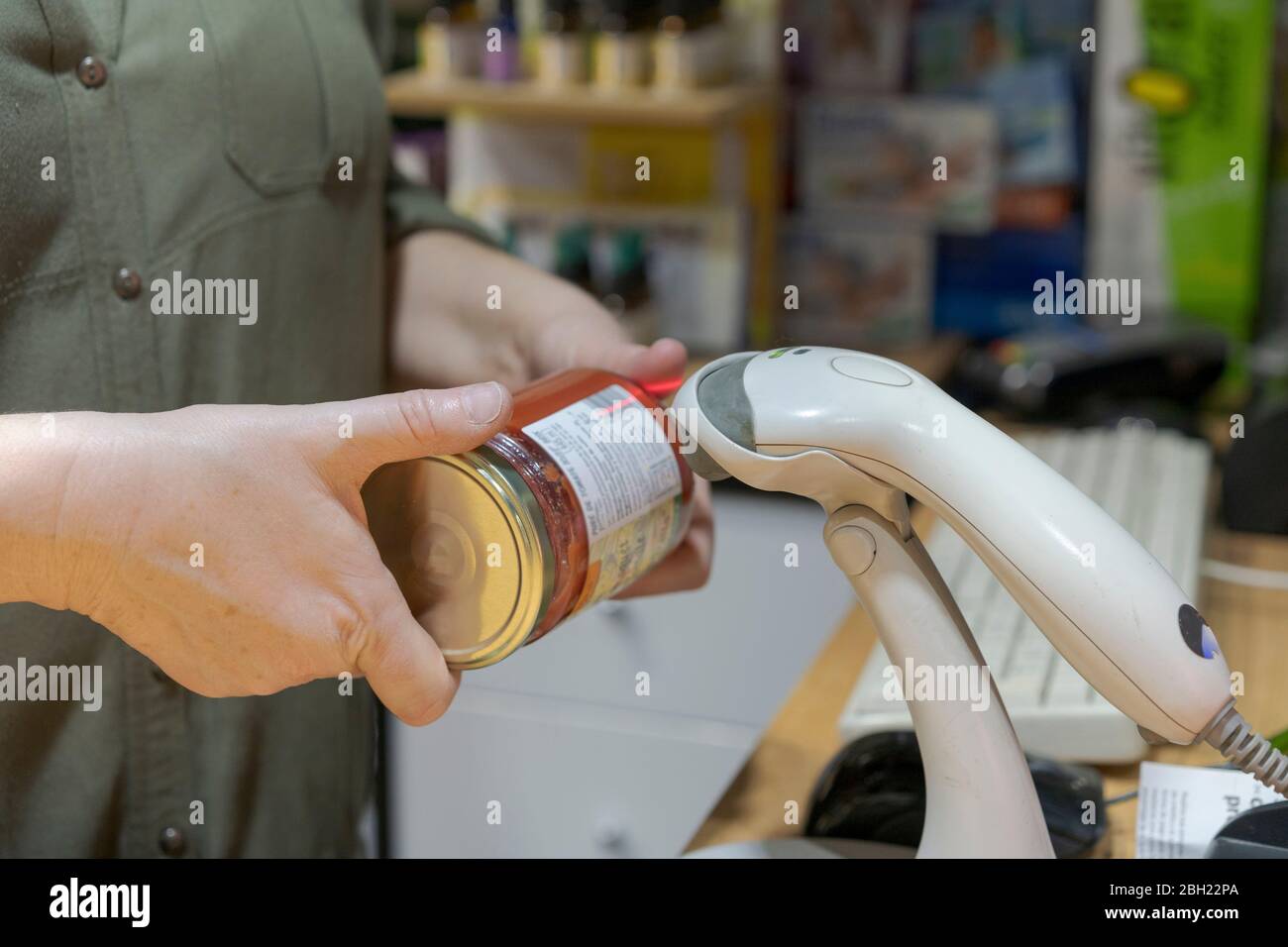 Vasetto di scansione dell'assistente di negozio al banco Foto Stock