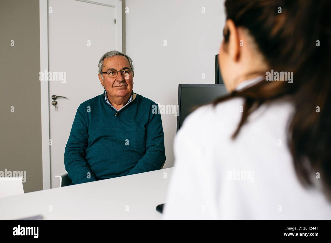 Paziente che guarda il medico durante una consultazione nella pratica medica Foto Stock