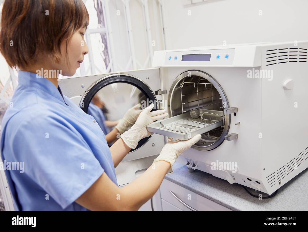 Assistente dentale in pratica strumenti di sterilizzazione Foto Stock