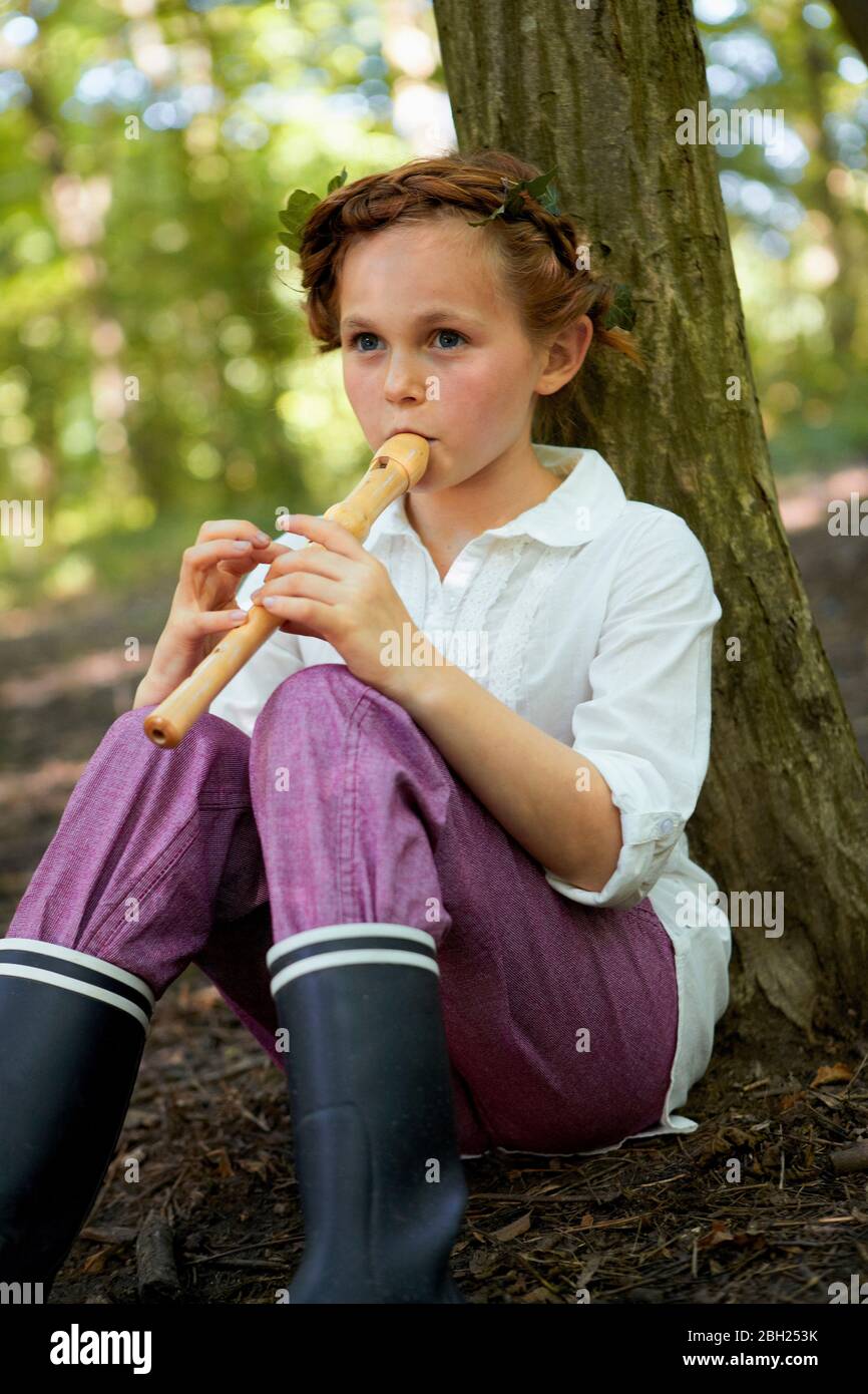 Ritratto di ragazza che gioca registratore in foresta Foto Stock