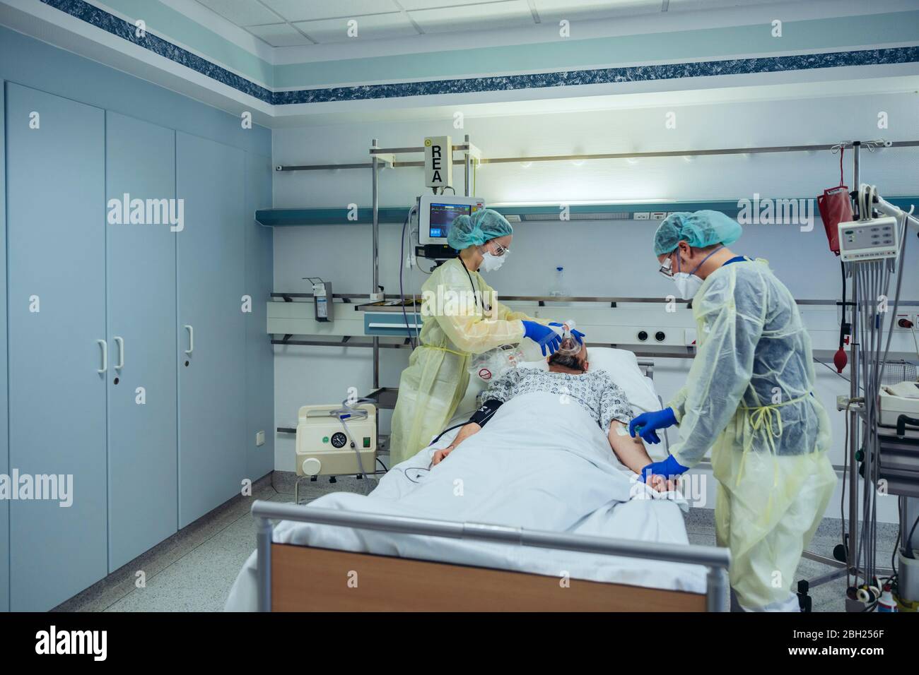 I medici si prendono cura del paziente nell'unità di pronto soccorso di un ospedale che cambia la respirazione dalla maschera di ossigeno alla maschera della valvola del sacchetto Foto Stock