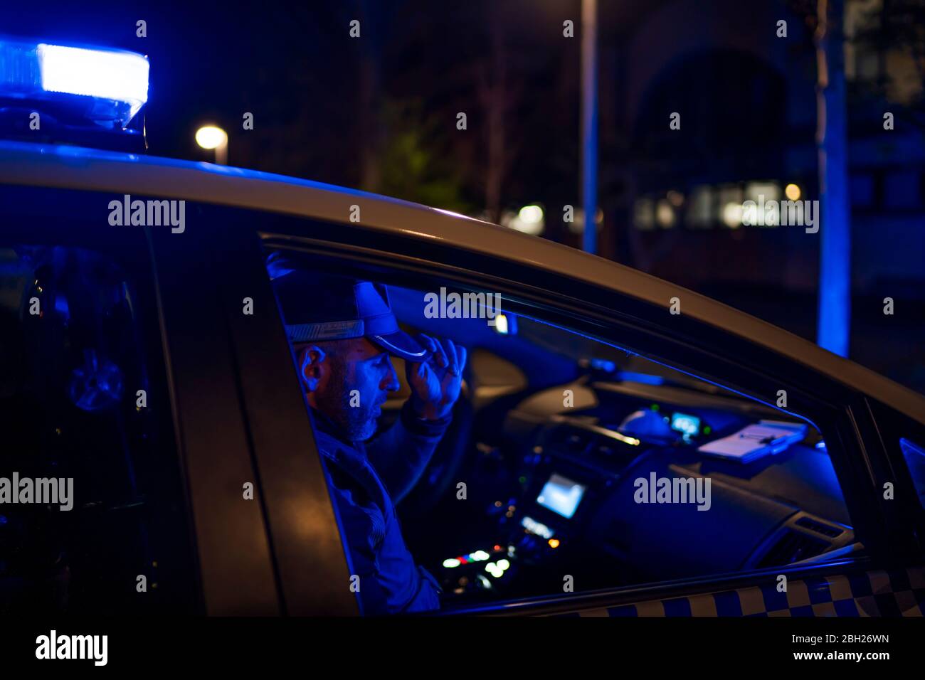 Poliziotto in missione di emergenza, seduto in auto Foto Stock