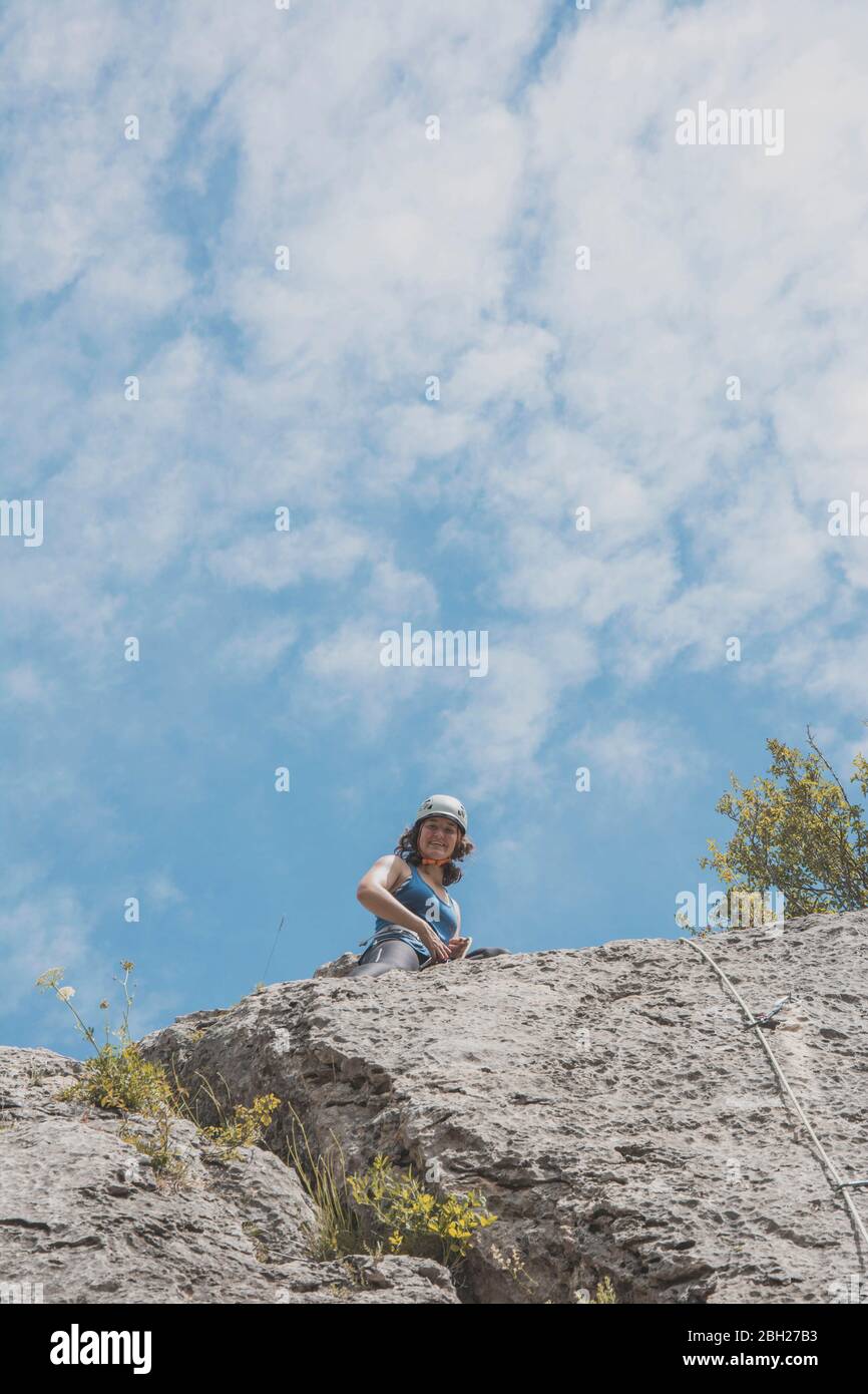 Arrampicata femminile di montagna in piedi sulla parete rocciosa Foto Stock