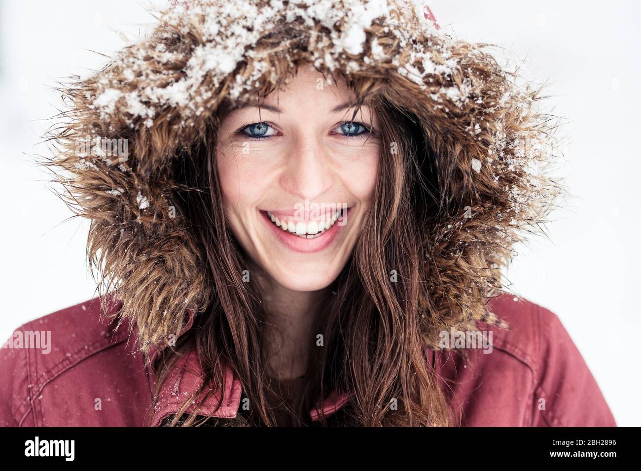 Ritratto di giovane donna ridente con occhi blu in inverno Foto Stock