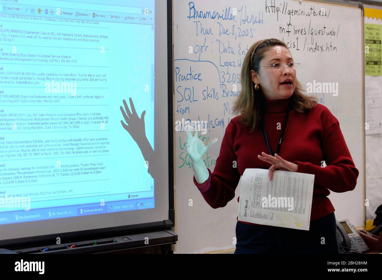 Brownsville Texas USA, dicembre 2005: Insegnante che utilizza le apparecchiature di proiezione in ambiente di apprendimento in aula. ©Bob Daemmrich Foto Stock