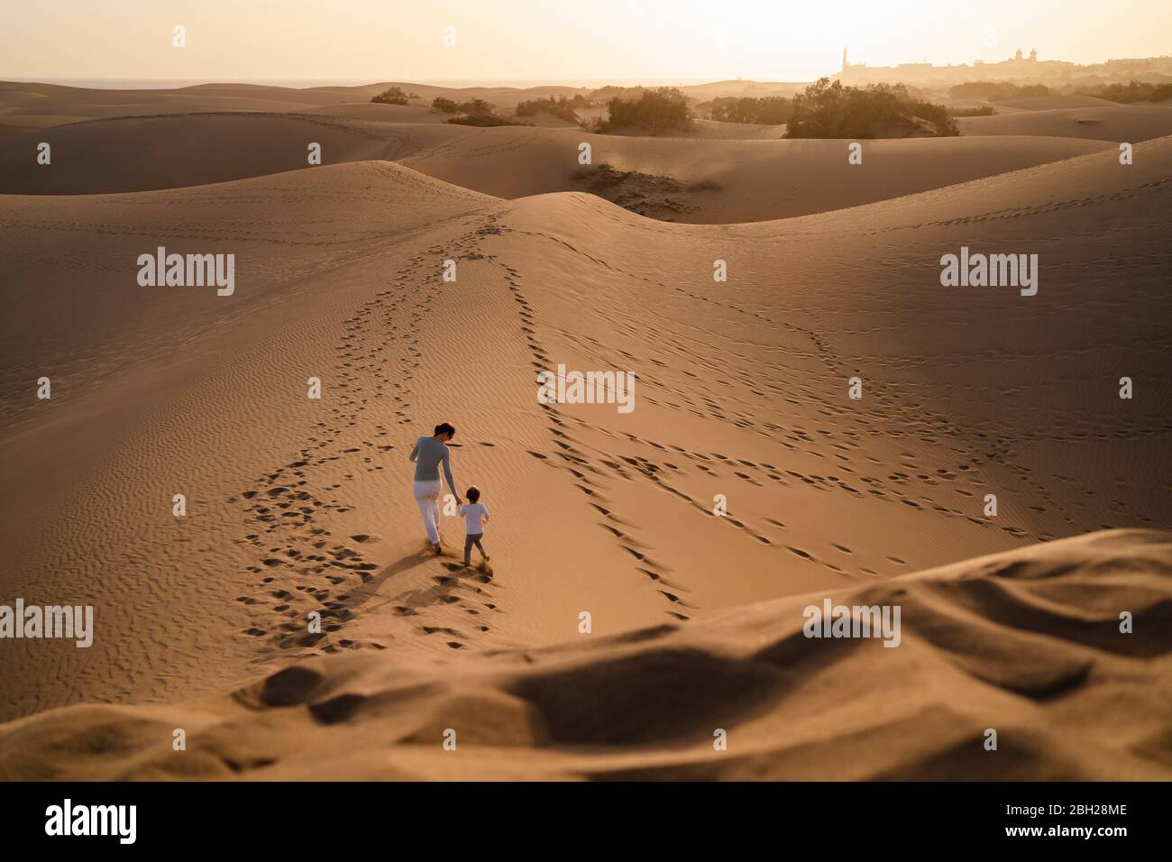 Madre e figlia camminano mano in mano nelle dune di sabbia, Gran Canaria, Spagna Foto Stock