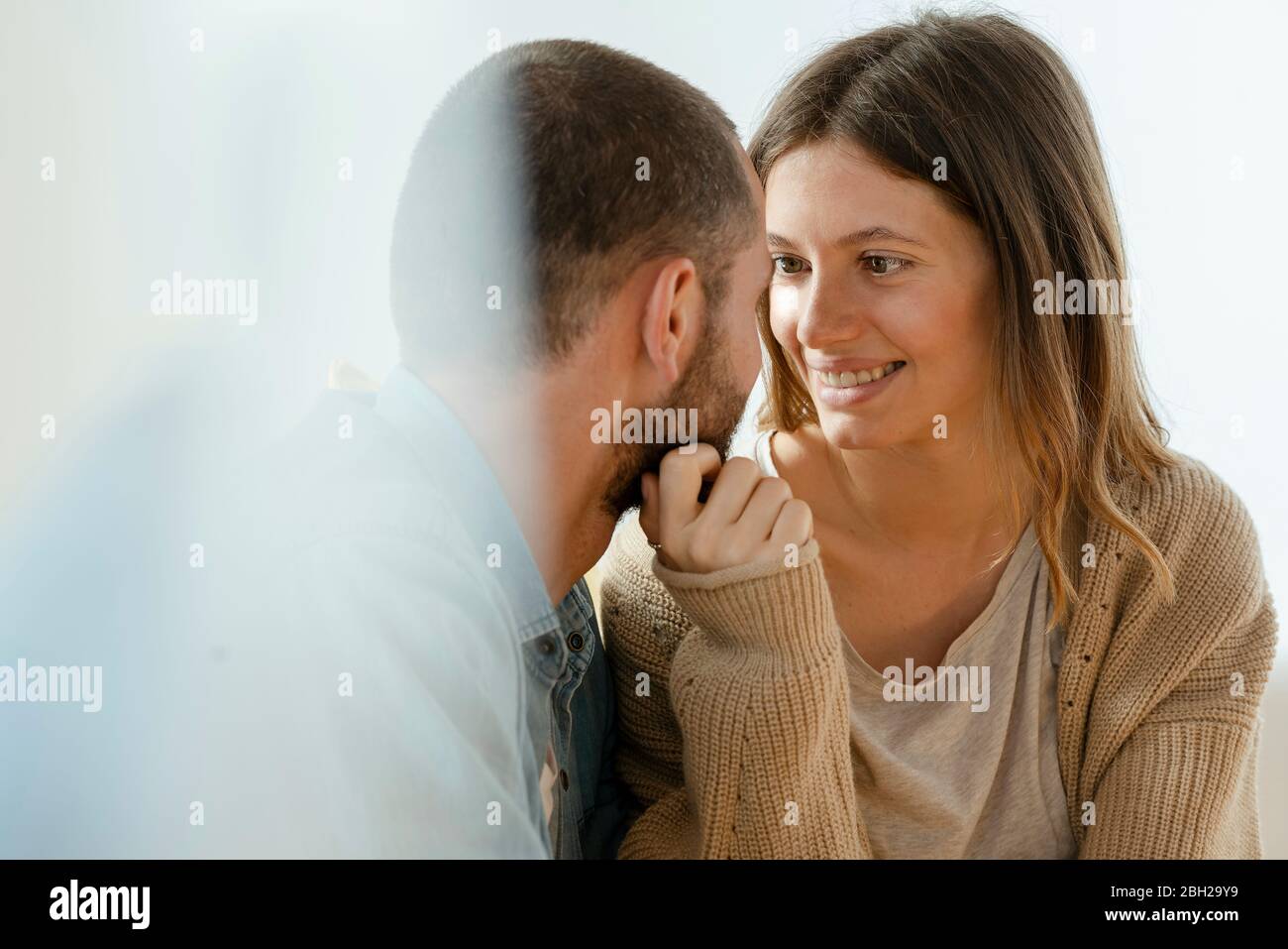 Affettuosa bella donna bruna sorridente al suo ragazzo che è innamorato e vicino insieme Foto Stock