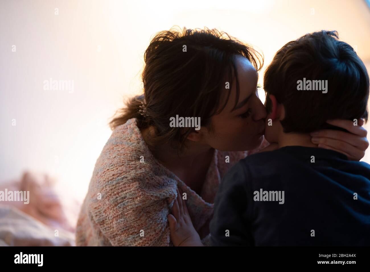 Madre baciare il suo piccolo figlio Foto Stock