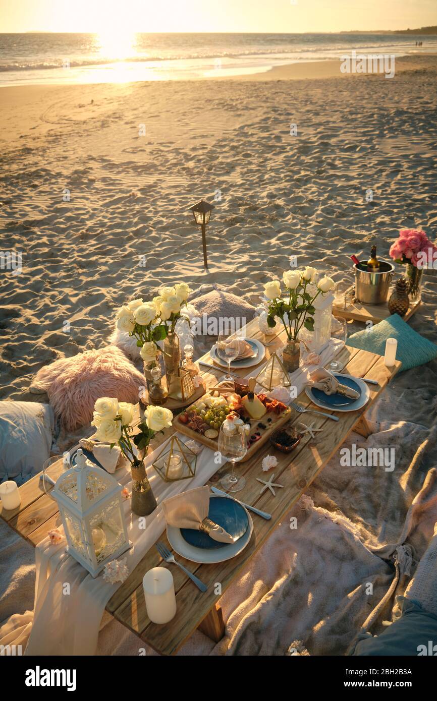 Vista ad alto angolo di un pasto fresco servito sul tavolo da pranzo della spiaggia durante il bellissimo tramonto, Nayarit, Messico Foto Stock
