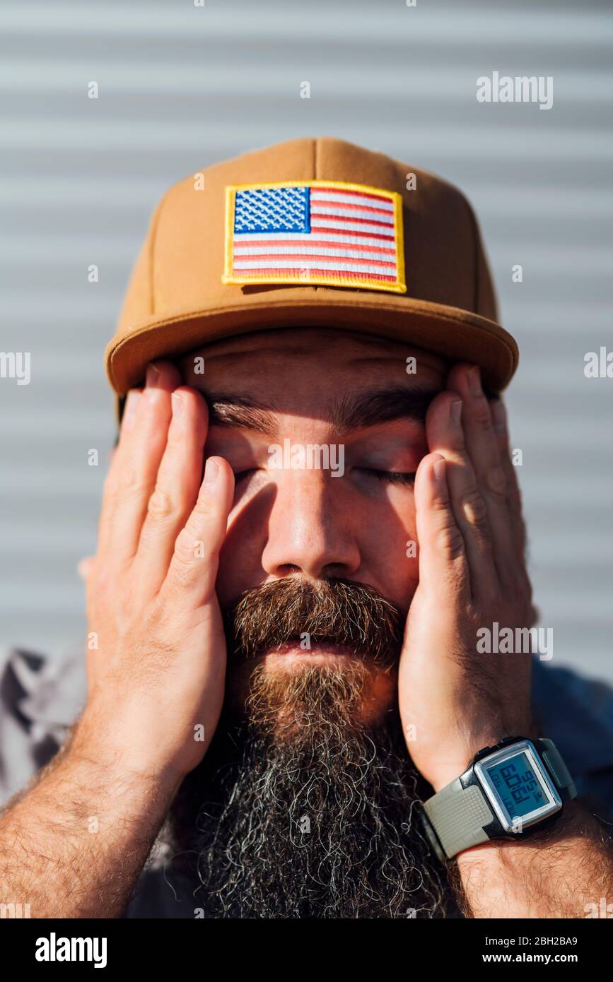 Uomo bearded che indossa il cappello da baseball con bandiera americana che  strofina il sudore dal viso Foto stock - Alamy