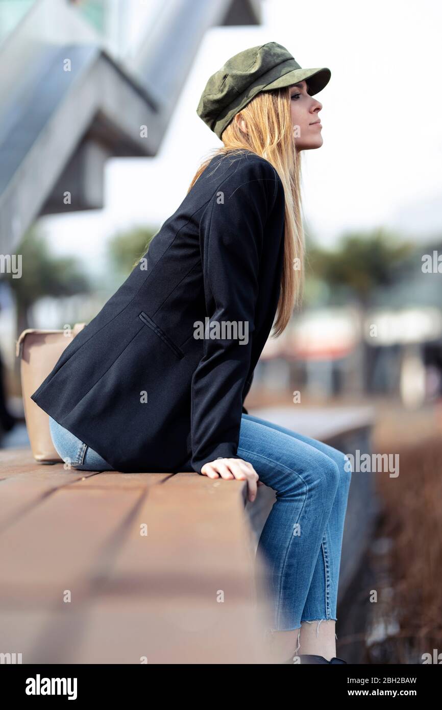 Giovane bionda che si rilassa su una panchina Foto Stock