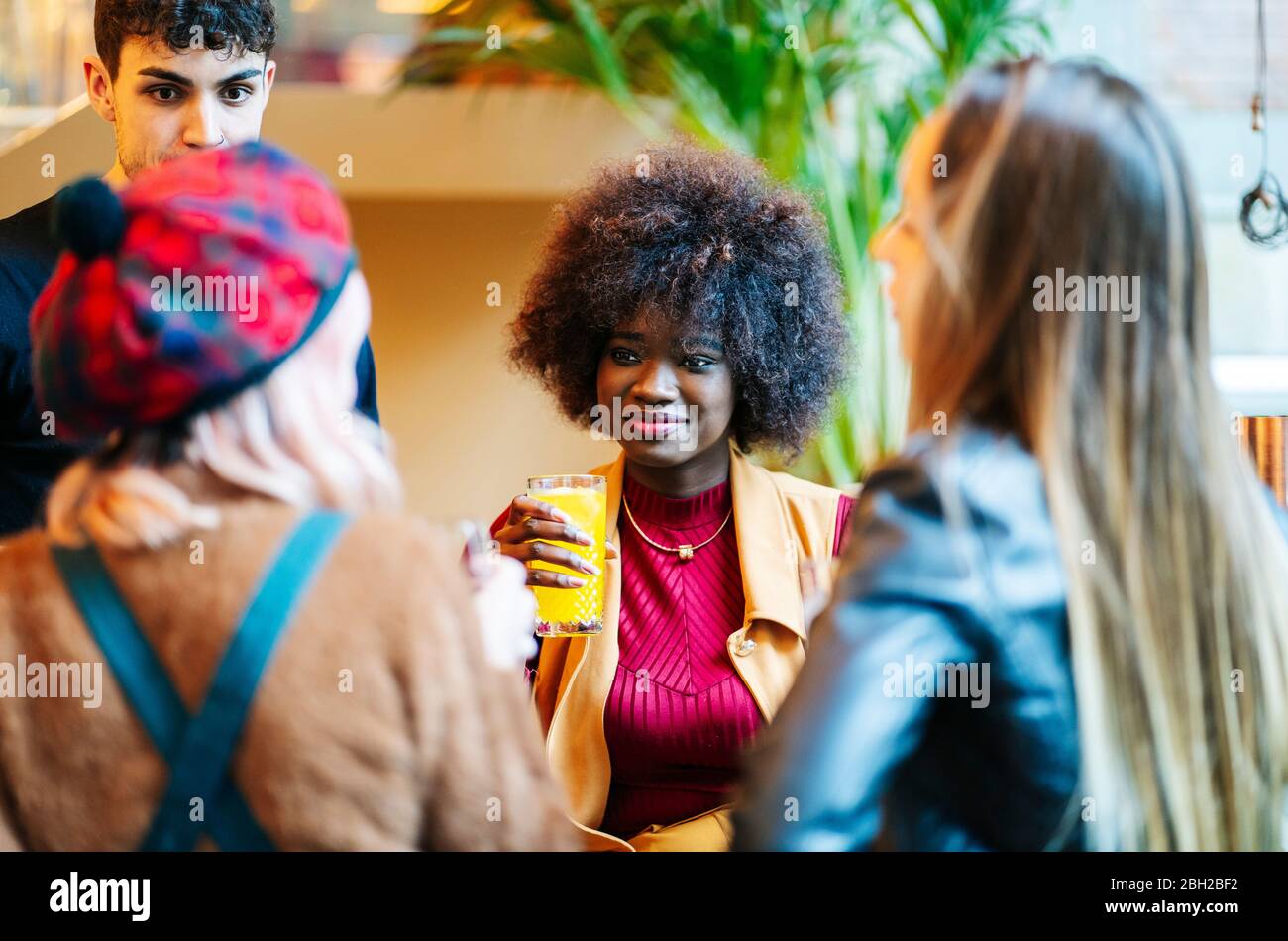 Gli amici si incontrano in un bar alla moda, parlano e bevendo un drink Foto Stock