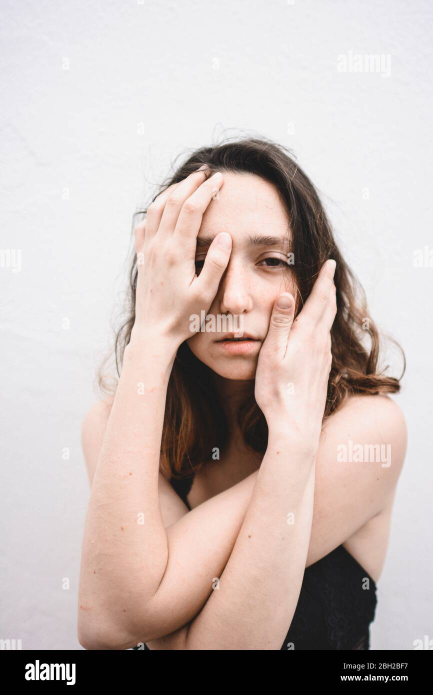 Ritratto di giovane donna depressa con le mani sul viso Foto Stock