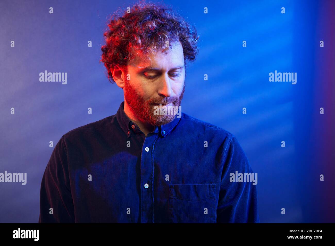 Ritratto di un uomo serio su una parete blu Foto Stock