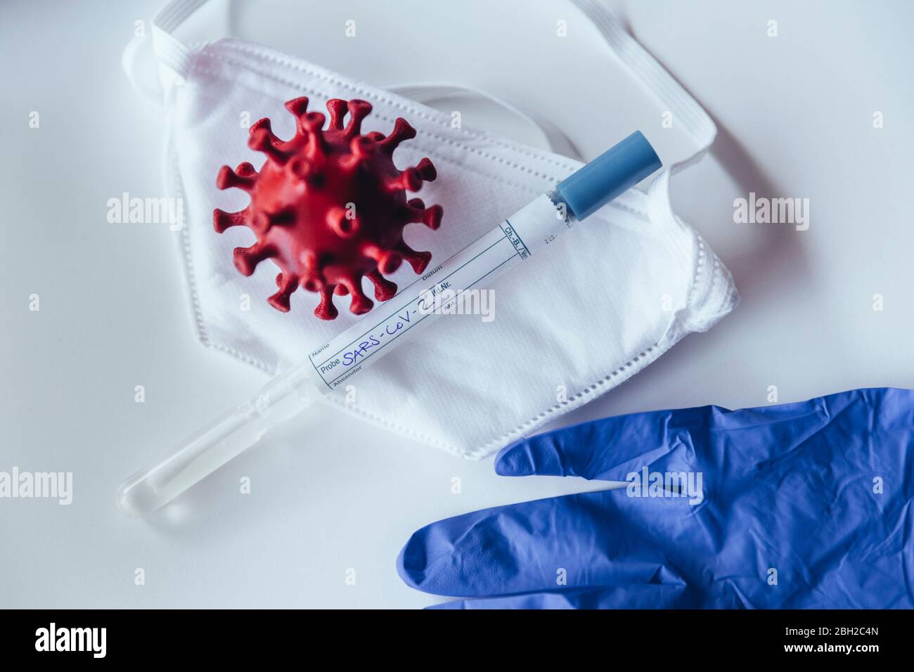 Modello di corona virus con kit di test su maschera medica Foto Stock