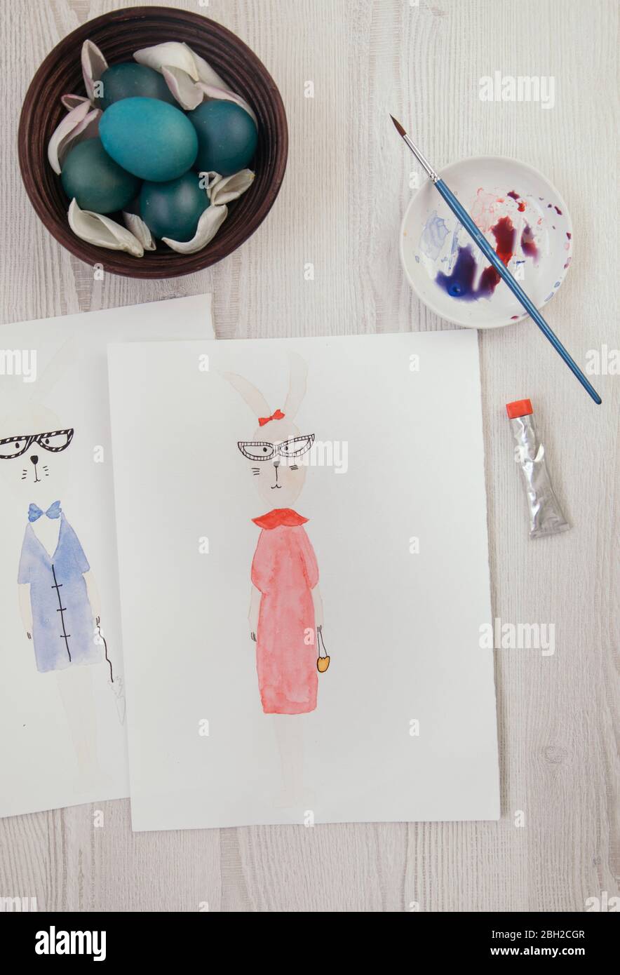 Uova di Pasqua e due dipinti acquerelli di coniglietti antropomorfi di Pasqua Foto Stock