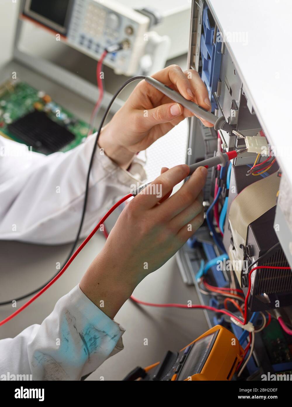 Tecnico femminile che lavora su un computer aperto, utilizzando un dispositivo di misurazione, primo piano Foto Stock