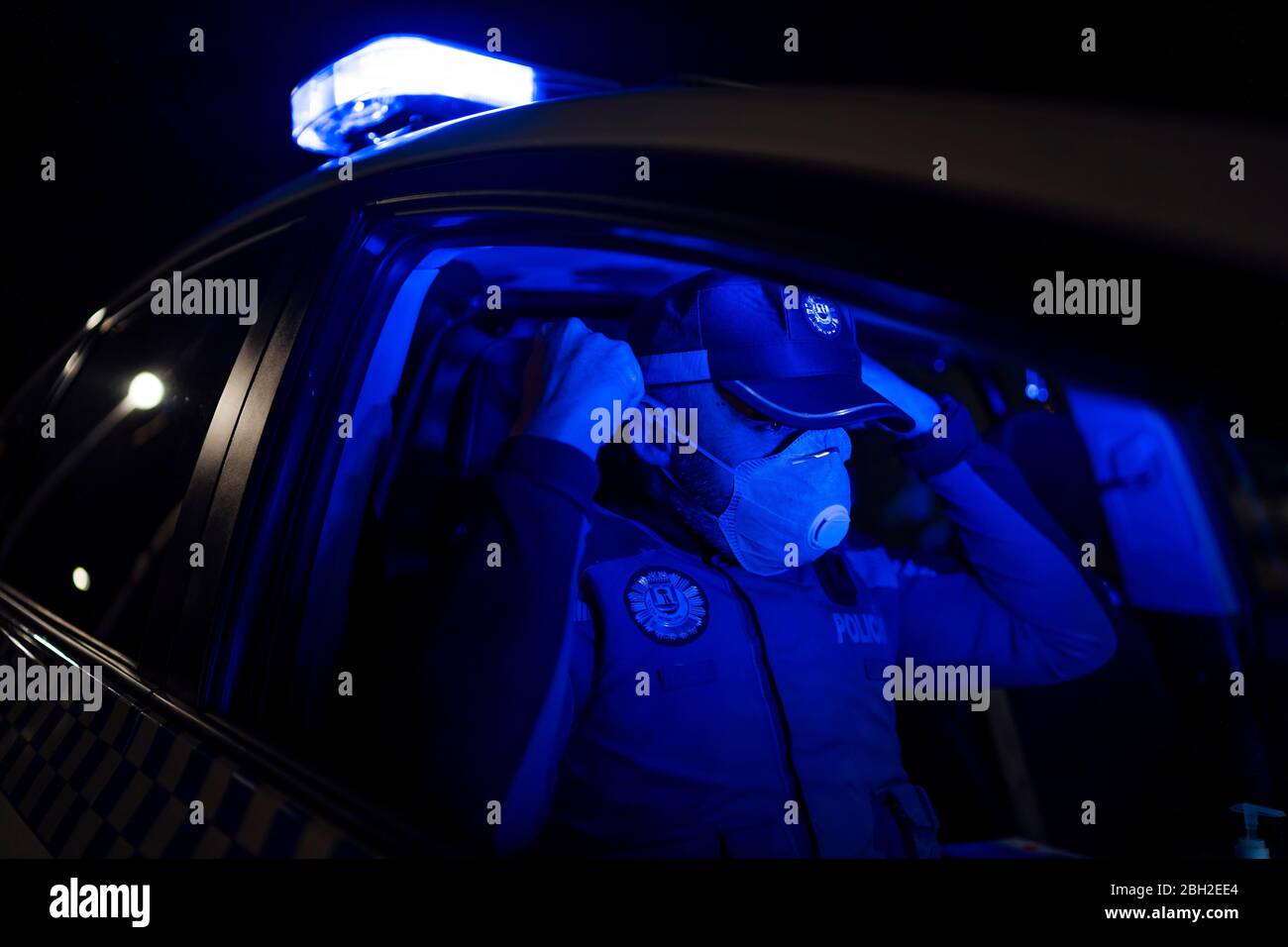 Poliziotto in missione di emergenza, mettendo sulla maschera facciale Foto Stock