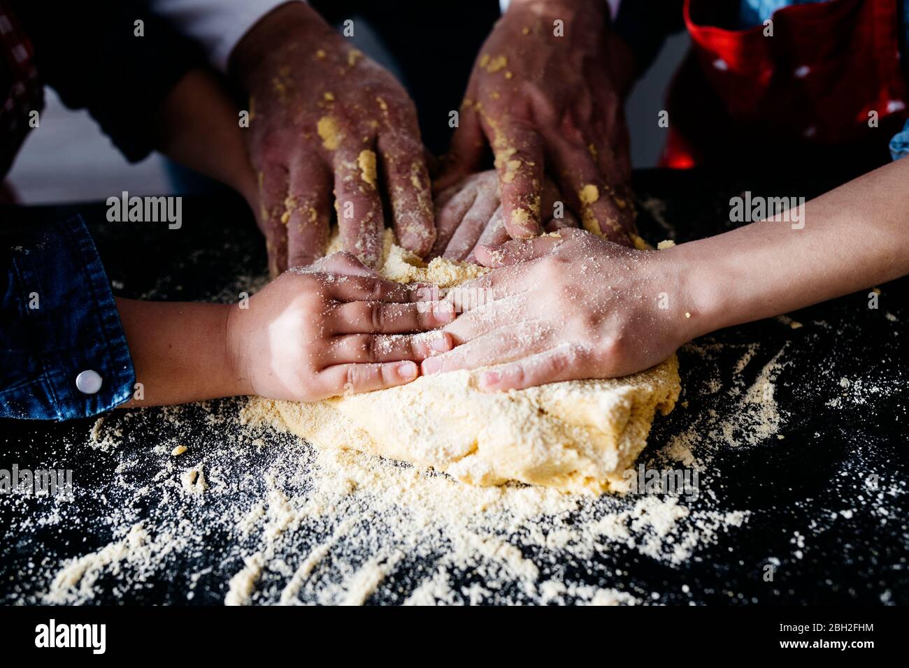 Primo piano di mani che preparano l'impasto in cucina a casa Foto Stock