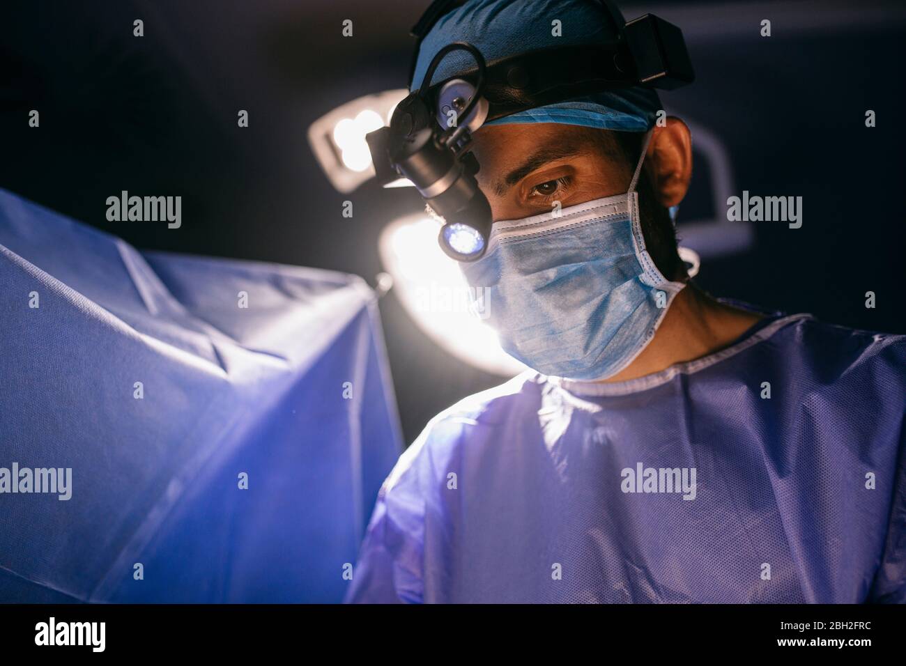 Ritratto di chirurgo focalizzato durante un'operazione Foto Stock