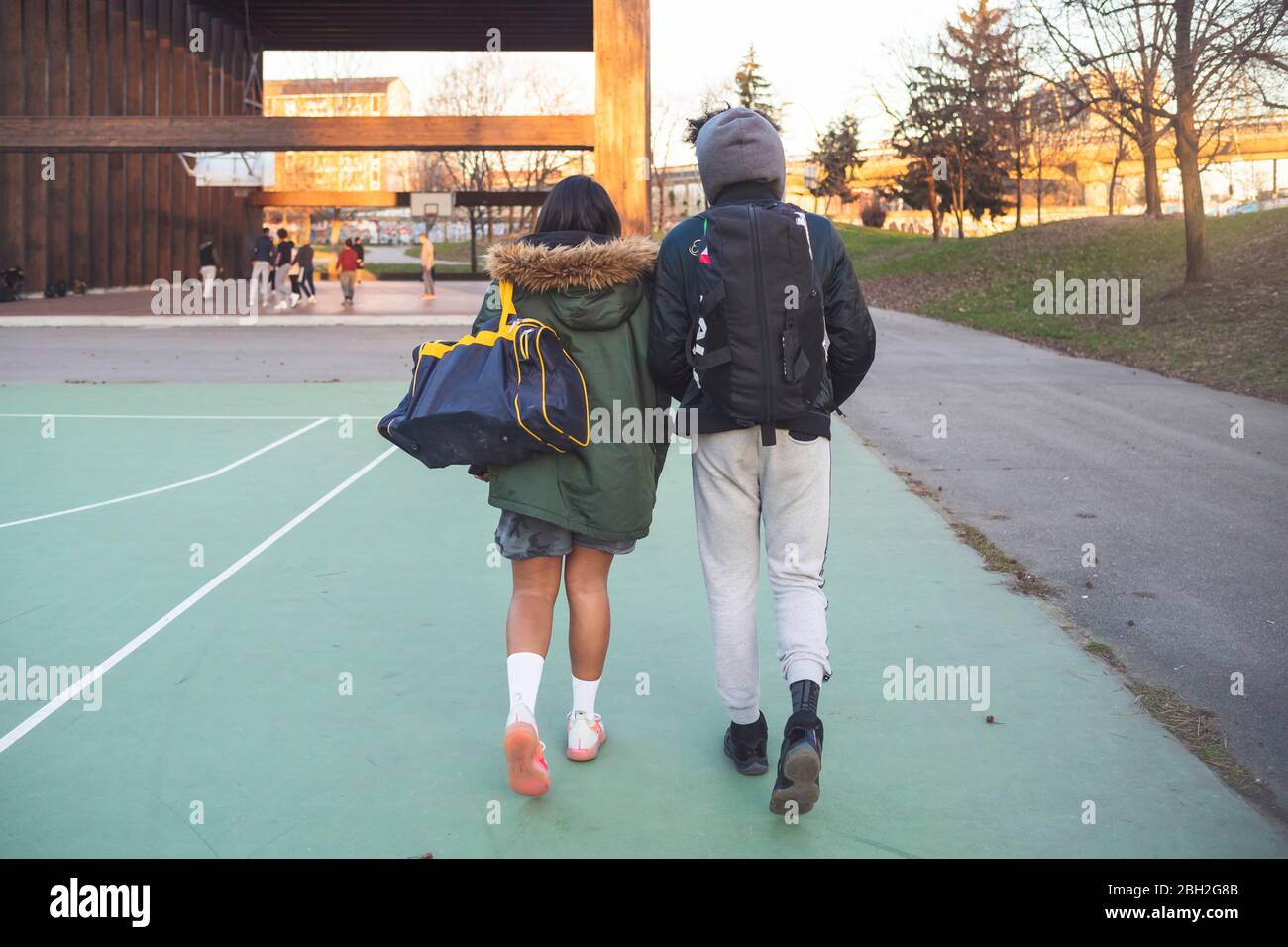 Vista posteriore di una giovane coppia che cammina sul campo sportivo Foto Stock