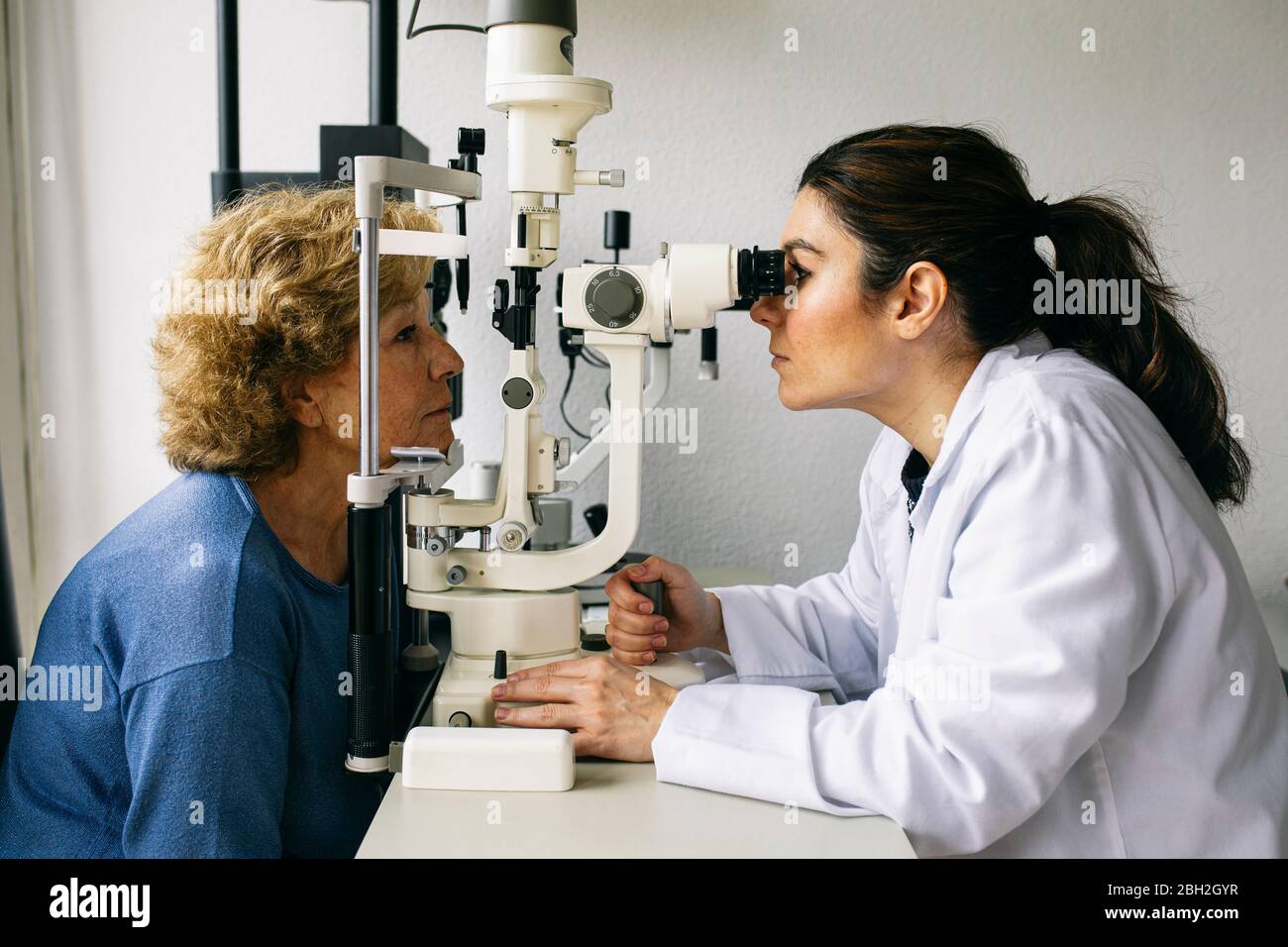 Oftalmologo che esamina la vista di un paziente anziano Foto Stock