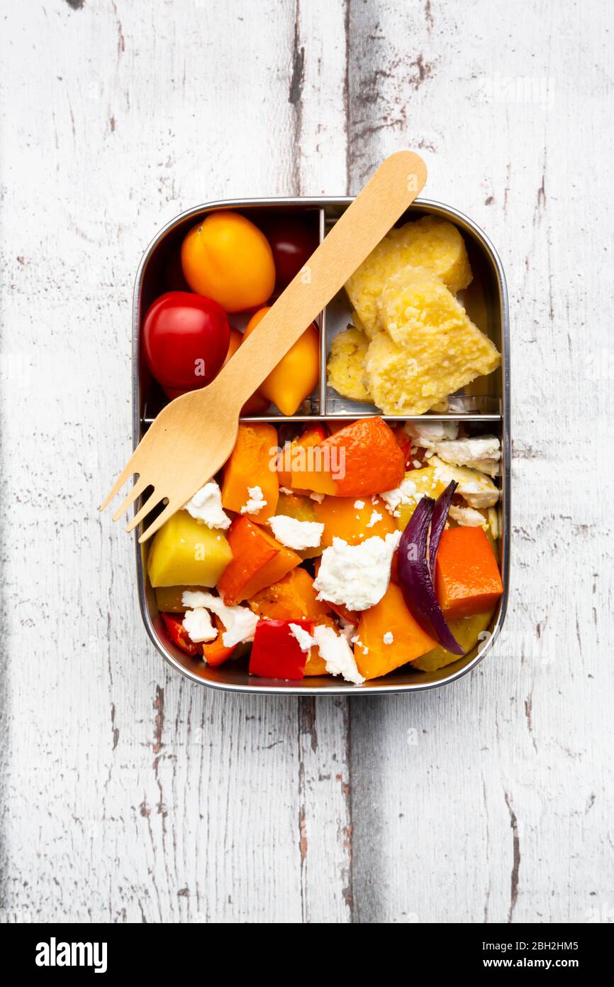 Pranzo al sacco con verdure cotte al forno d'autunno, formaggio feta e polenta a forma di cuore Foto Stock