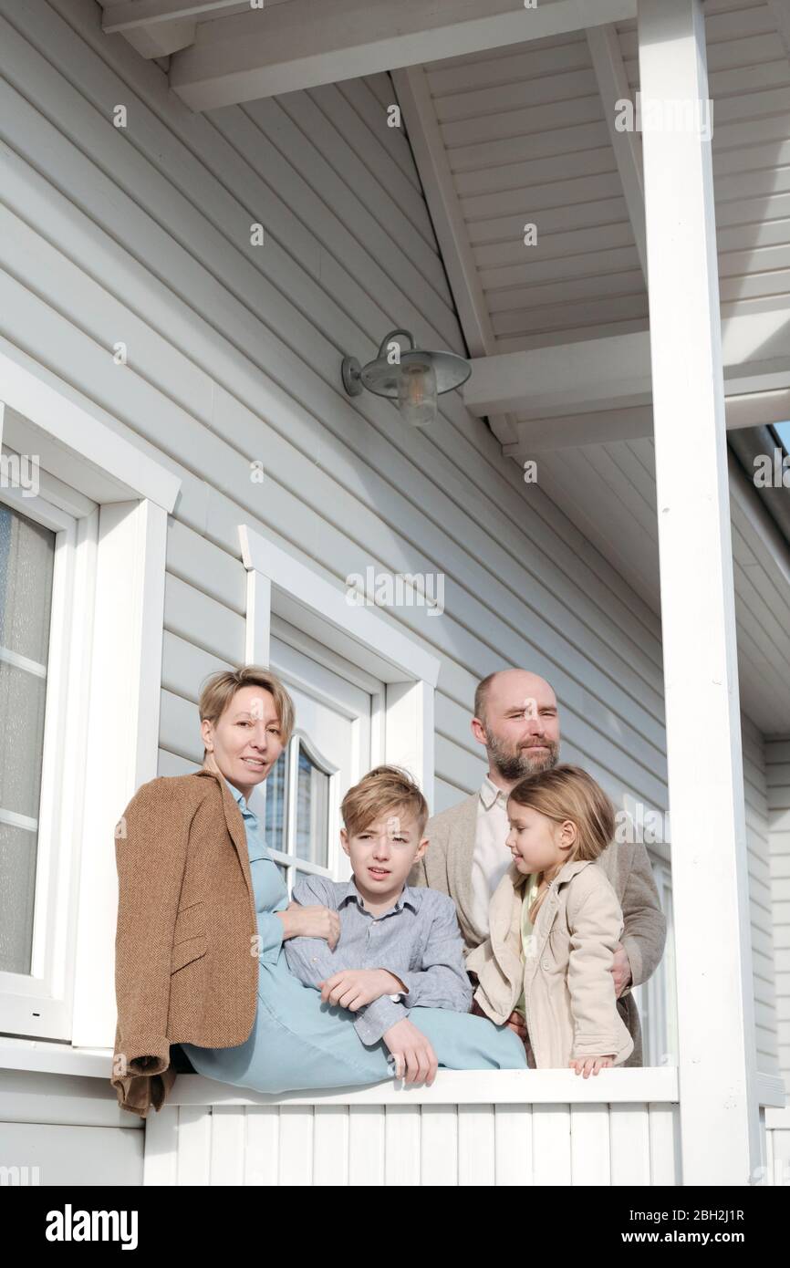Ritratto di famiglia sul portico della loro casa Foto Stock