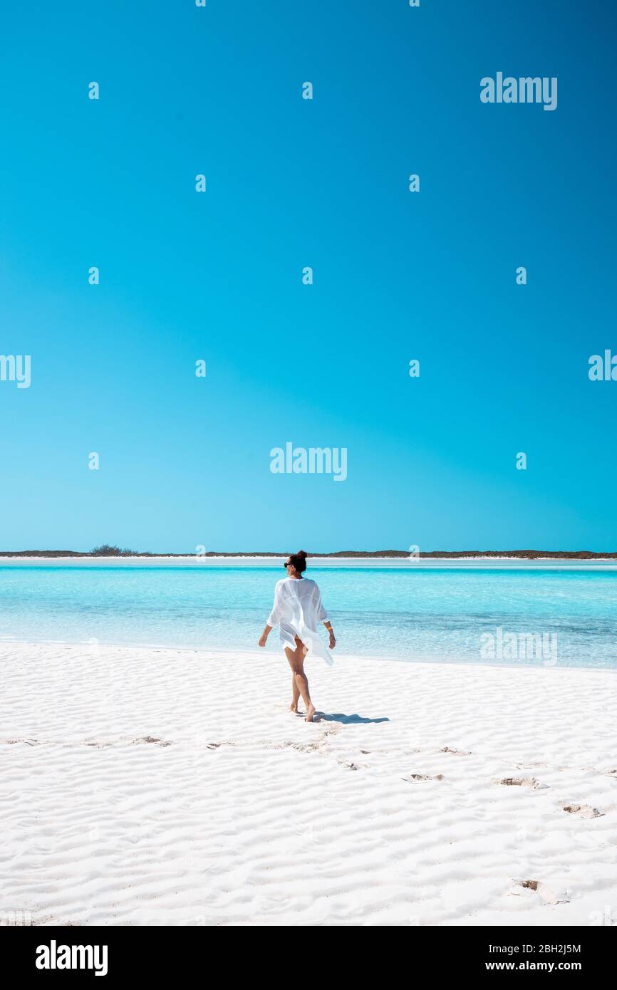 Donna che cammina sulla riva bianca del mare, Bahamas, Carribean Foto Stock