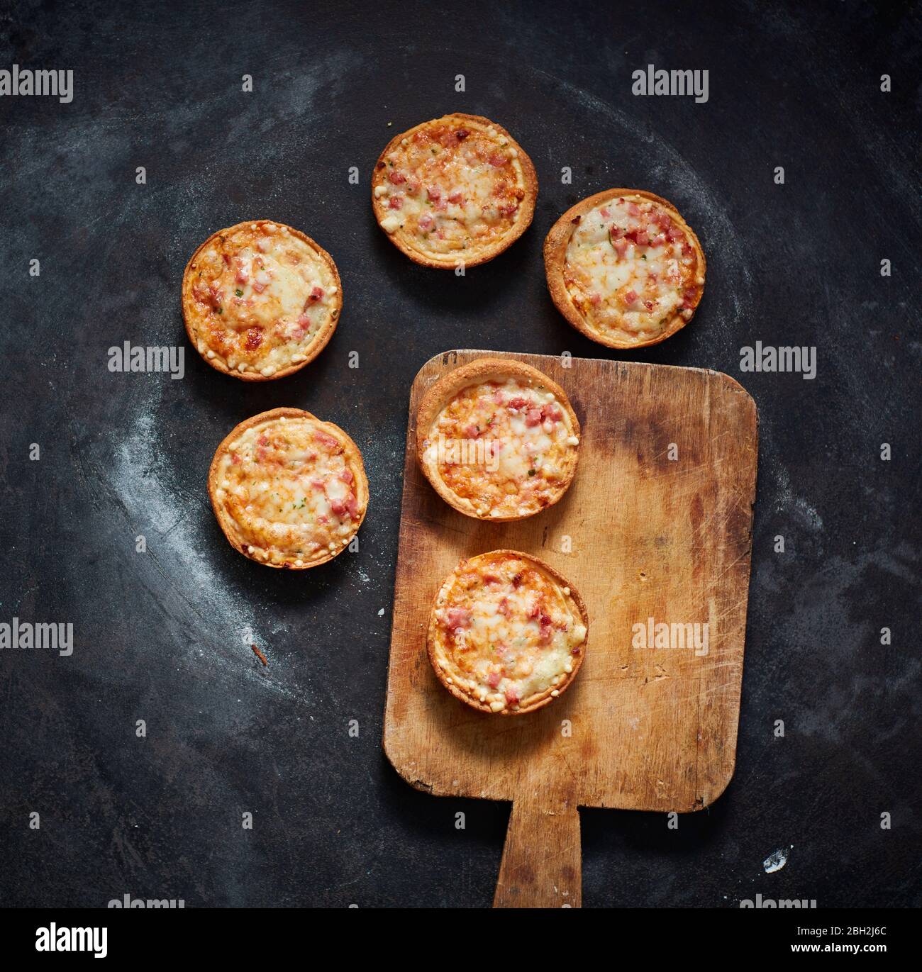 Spatola e mini pizze con formaggio, pomodori e prosciutto Foto Stock