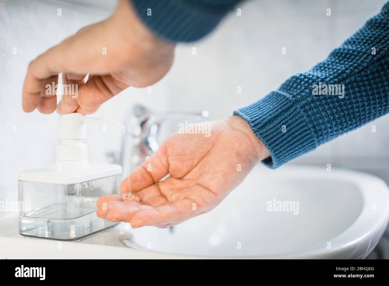 Uomo che lava le mani con sapone liquido, primo piano Foto Stock
