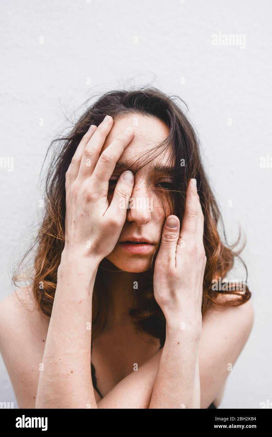 Ritratto di giovane donna depressa con le mani sul viso Foto Stock