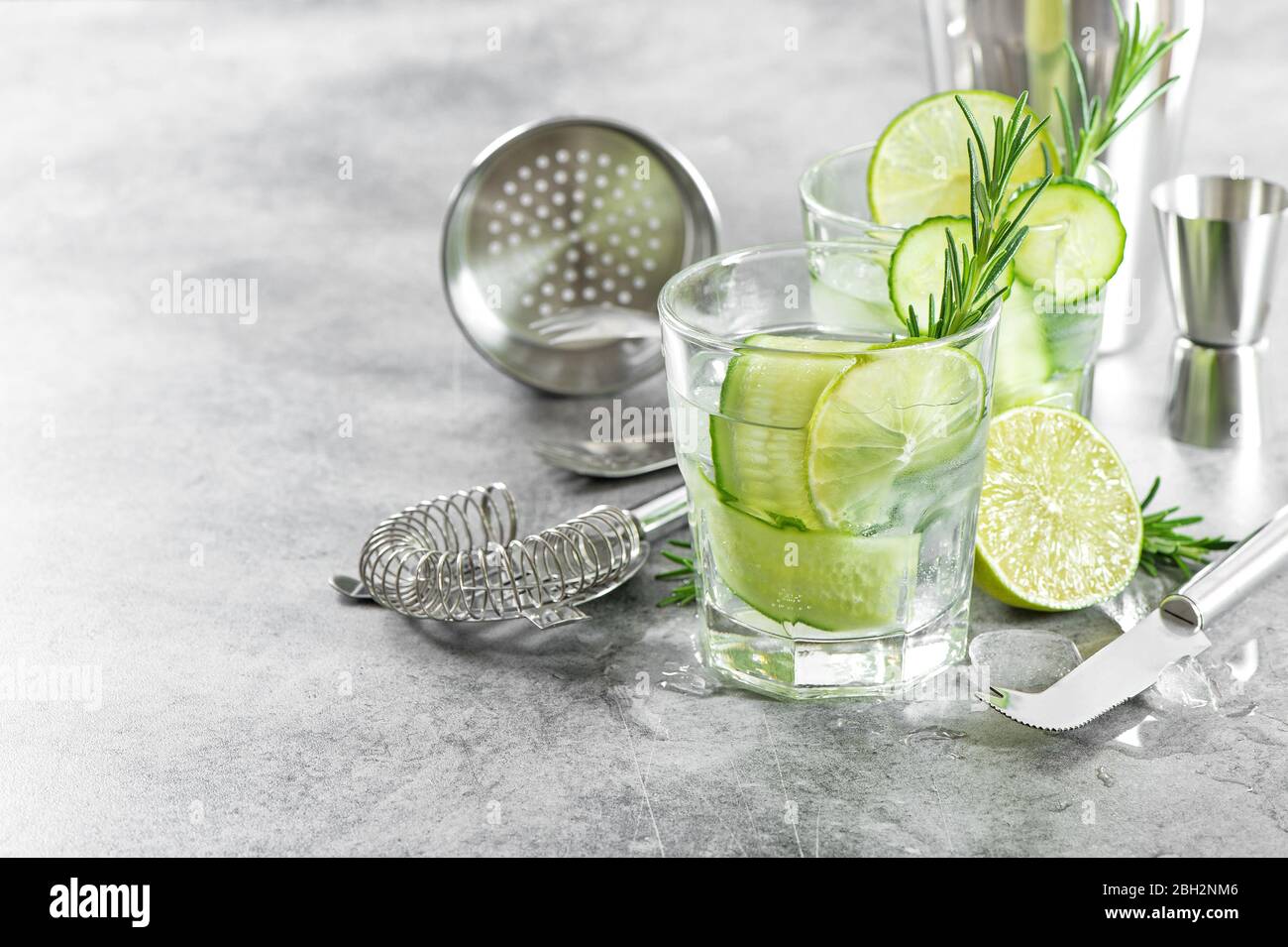 Accessori per bar e ingredienti per cocktail drink con cetrioli, lime, rosmarino, ghiaccio Foto Stock