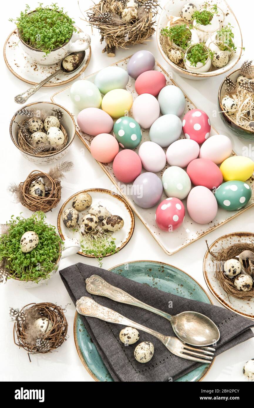 Pasqua tavolo luogo decorazione con uova colorate e vintage stoviglie Foto Stock