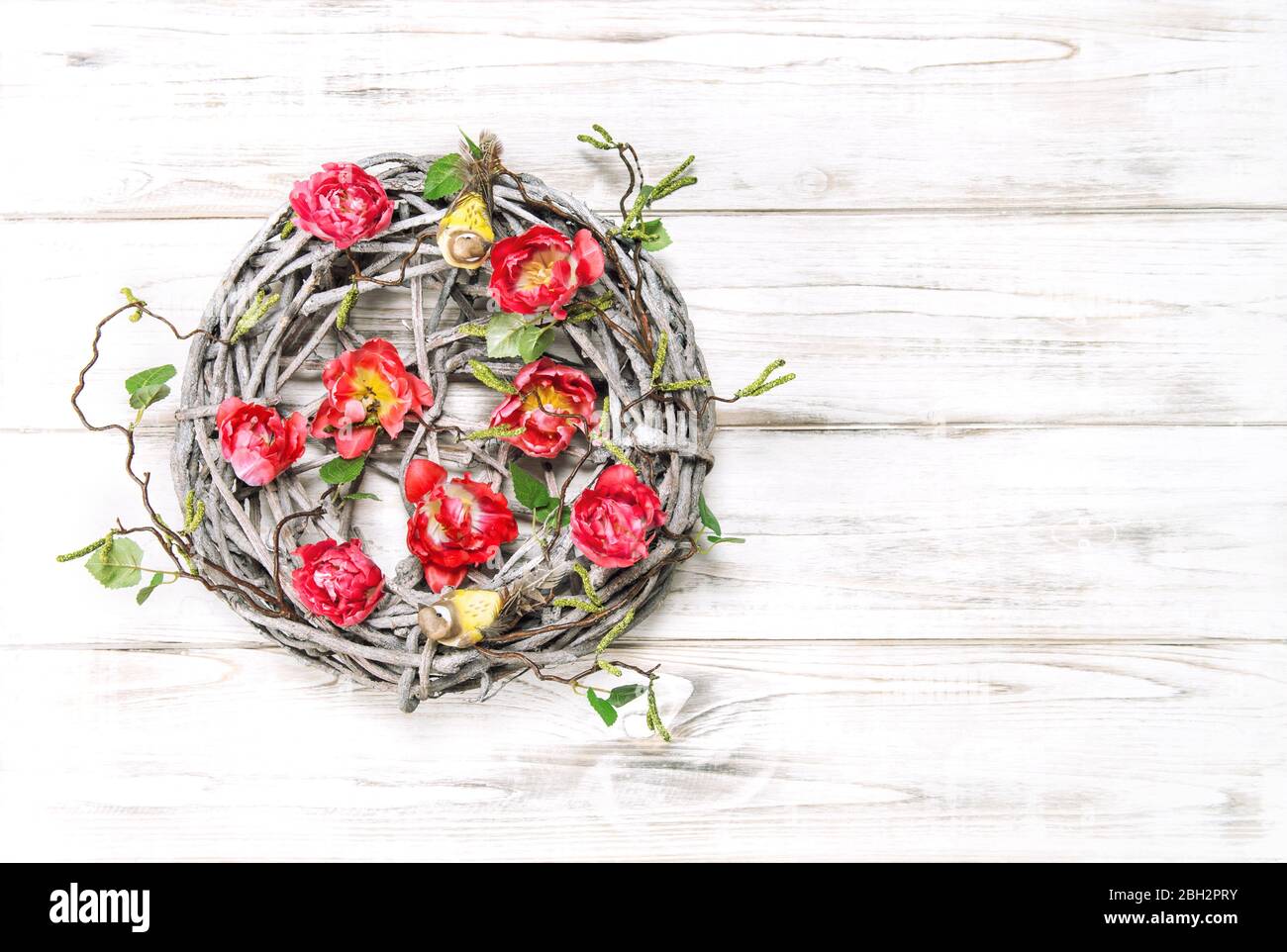 Corona di Pasqua con fiori di tulipano rossi. Decorazione casa stile vintage Foto Stock