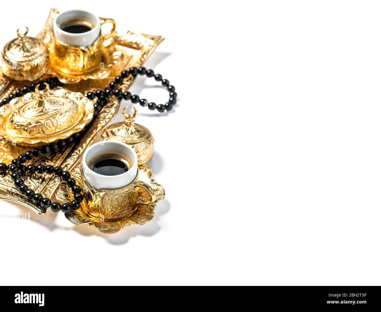 Piatti di caffè dorato e perle di rosario nero su sfondo bianco. Ramadan kareem Foto Stock
