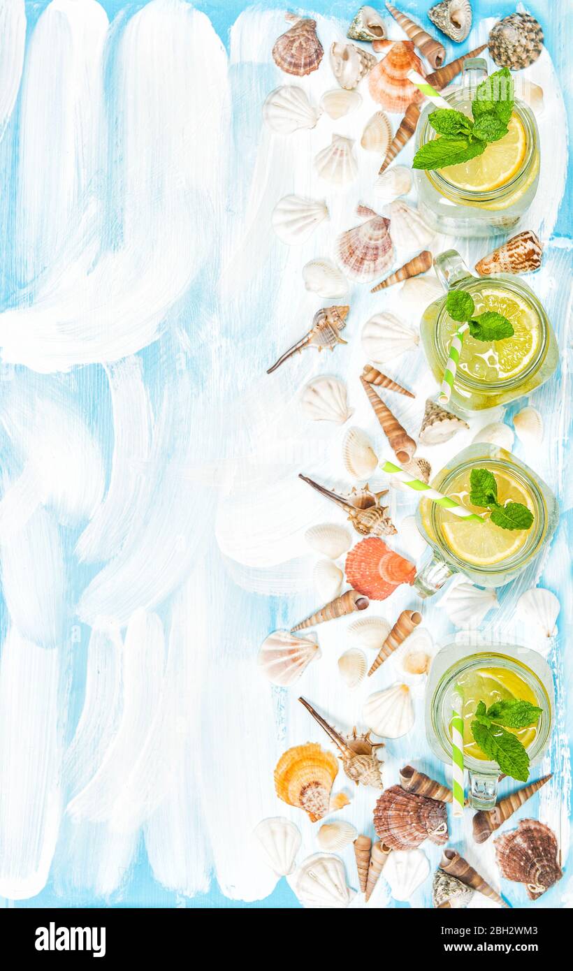 Bere con lime, limone, menta e ghiaccio. Decorazione fredda estate limonata conchiglie Foto Stock