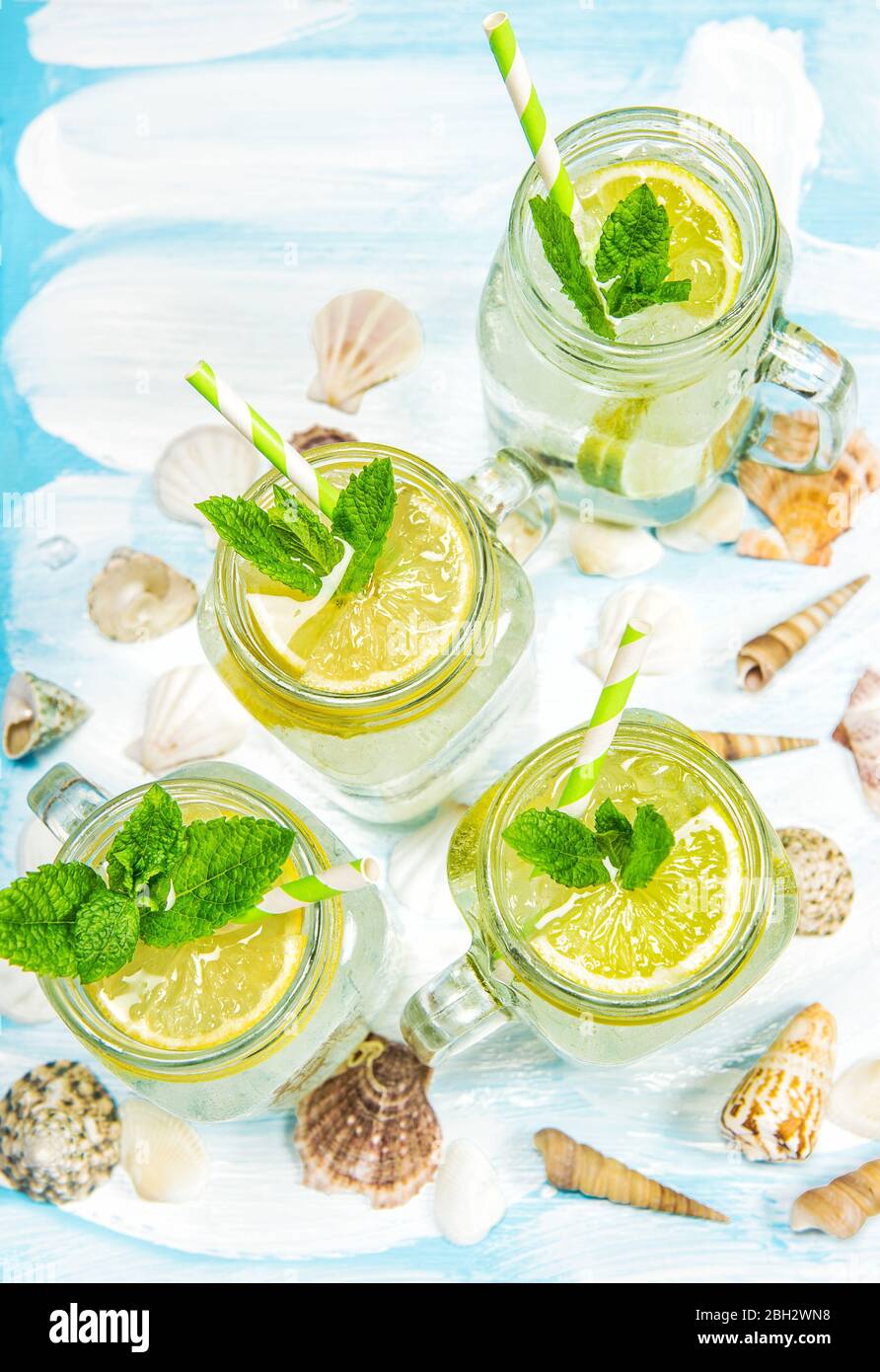 Cocktail con limone, menta e ghiaccio. Decorazione estiva di conchiglie di mare limonata Foto Stock