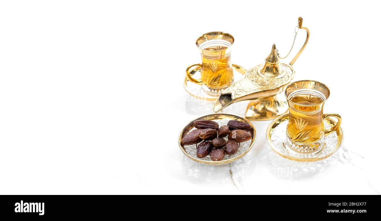 Bicchieri da tè con datteri e decorazioni lanterne dorate. Ospitalità orientale. Ramadan kareem Foto Stock
