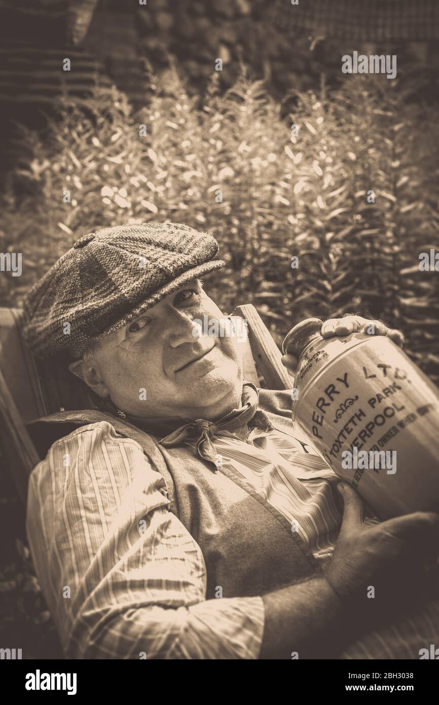 Ritratto sepia d'epoca in vecchio stile degli anni '40, uomo rilassante in giardino, alcol da bere, Museo del Paese Nero, evento estivo della seconda guerra mondiale degli anni '40, Regno Unito. Foto Stock