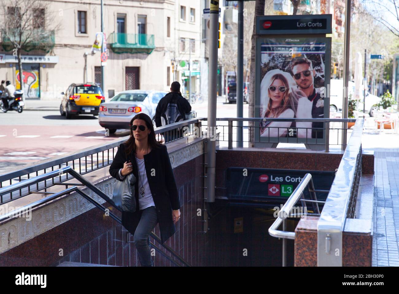 Barcellona, Spagna - 9 aprile 2015: Una giovane donna che indossa occhiali da sole uscendo dalla stazione della metropolitana Les Corts Foto Stock
