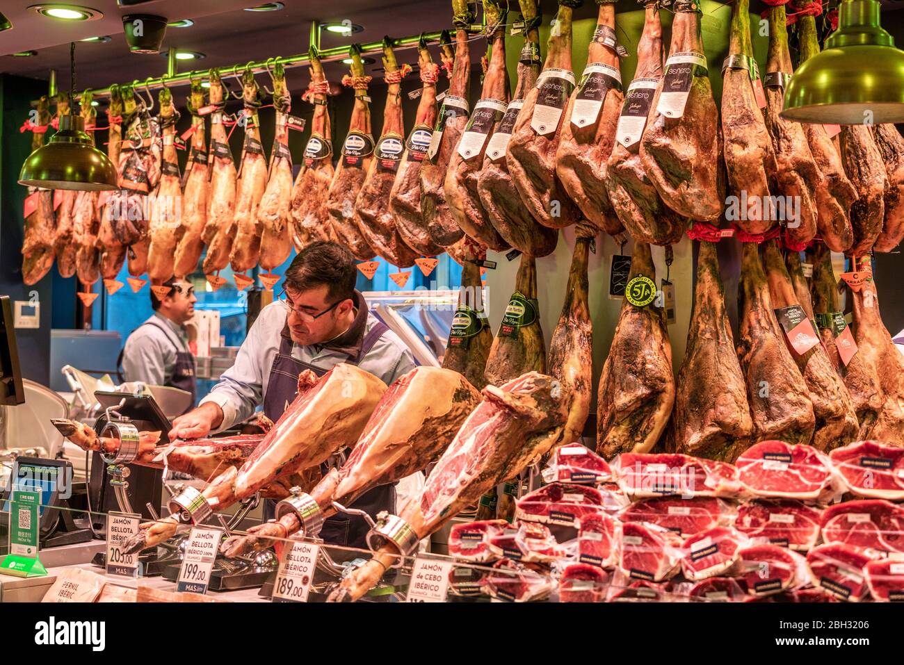 Mercat de la Boqueria, uomo taglio Jamon Serrano, Stalla prosciutto, mercato, Barcellona, Spagna Foto Stock